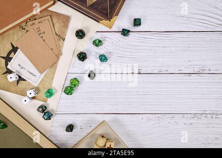 Rôle de table jouant fond plat de lay avec dés de RPG, livres de règles, carte de donjon sur fond en bois blanc avec espace de copie Banque D'Images