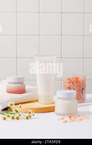 Un ensemble de paquets cosmétiques présentés dans la salle de bain avec un pot contenant du sel rose de l'himalaya. Le sel rose de l'himalaya ne provient pas techniquement de l'Himala Banque D'Images