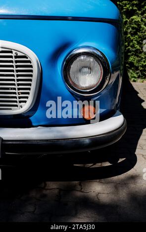 Fragment d'une voiture rétro bleue gros plan. Phare, pare-chocs Banque D'Images