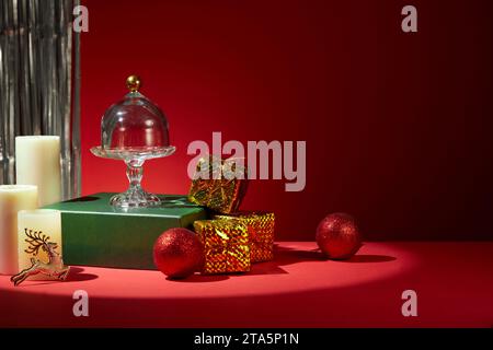 Idées pour décorer la table de Noël avec des tons rouges. Des décorations colorées sont placées sur la table, des perles, des boîtes-cadeaux de bougies parfumées sont décorées wi Banque D'Images