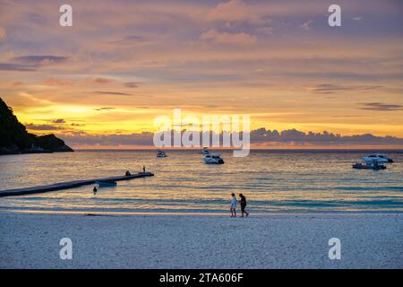 Un coucher de soleil doré vibrant sur le sable blanc et les eaux calmes de Patok Beach - Koh Racha Yai, une petite île près de Phuket, en Thaïlande Banque D'Images