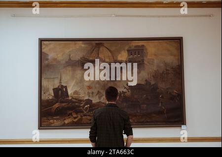 SHYMKENT, KAZAKHSTAN - 26 MARS 2023 : l'homme regarde une peinture lors d'une exposition au Musée des Beaux-Arts de Shymkent Banque D'Images