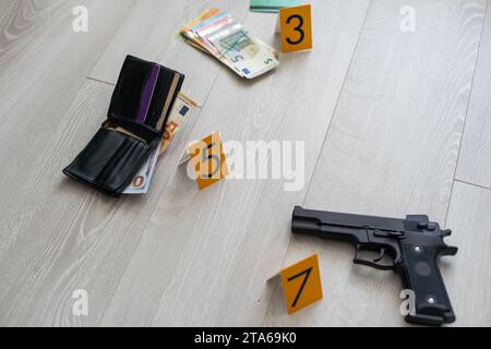 Enquête sur les lieux du crime - numérotation des preuves après le meurtre dans l'appartement. Porte-fusée, portefeuille et vêtements en laiton avec marqueurs de preuve Banque D'Images