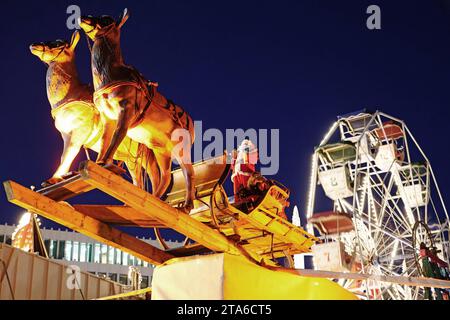 AM Rande des Bremer Weihnachtsmarkts, auf dem Domshof, schwebt der Weihnachtsmann mit seinem Rentierschlitten durch die Luft. *** Au bord du marché de Noël de Bremens, sur le Domshof, le Père Noël flotte dans les airs dans son traîneau à rennes Banque D'Images