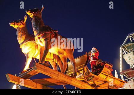 AM Rande des Bremer Weihnachtsmarkts, auf dem Domshof, schwebt der Weihnachtsmann mit seinem Rentierschlitten durch die Luft. *** Au bord du marché de Noël de Bremens, sur le Domshof, le Père Noël flotte dans les airs dans son traîneau à rennes Banque D'Images