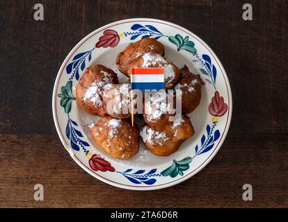 Oliebollen hollandais traditionnel sur l'assiette avec drapeau hollandais Banque D'Images