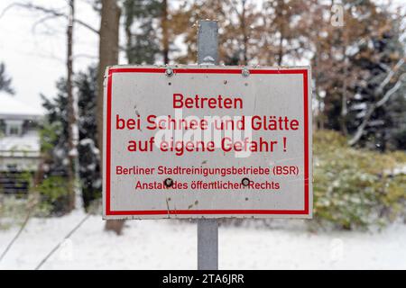 29.11.2023, Berlin, Schnee im Herbst, Schild:Betrett BEI Schnee und Glätte auf eigene Gefahr BSR *** 29 11 2023, Berlin, neige en automne, panneau entrer dans des conditions enneigées et glissantes à vos propres risques BSR crédit : Imago/Alamy Live News Banque D'Images