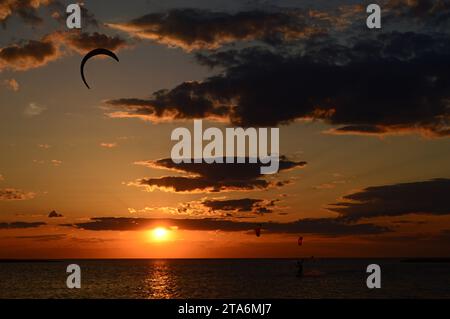 Un kite surfer fait une dernière course alors que le soleil se couche sur la baie sur les Outer Banks de Caroline du Nord Banque D'Images