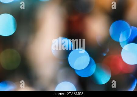 Guirlande de Noël bleue et or lumières bokeh sur un arbre, fond flou multi-couleur abstrait. Banque D'Images