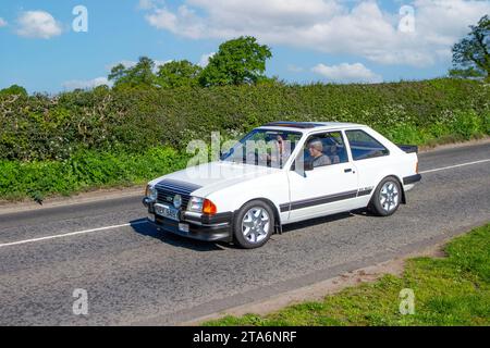 Années 1983 80 blanc Ford Escort GL RS1600, 1597 cc voiture manuelle à 5 vitesses ; Vintage, moteurs classiques restaurés, collectionneurs automobiles passionnés d'automobile, voitures anciennes voyageant dans le Cheshire, Royaume-Uni Banque D'Images