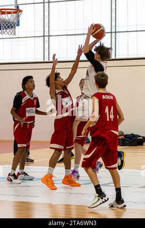 Adolescents jouant à un match de basket-ball au stade municipal d'Agen, France Banque D'Images