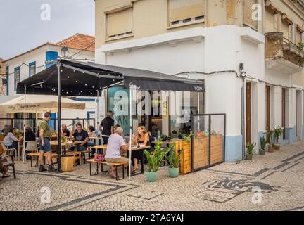 Les gens dans un café en plein air dans les rues de Sines au Portugal Banque D'Images