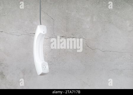 Combiné téléphonique blanc avec ombre douce sur gris Banque D'Images