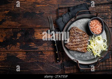 Steak de chevreuil avec sel de mer et salade. Fond en bois. Vue de dessus. Espace de copie. Banque D'Images