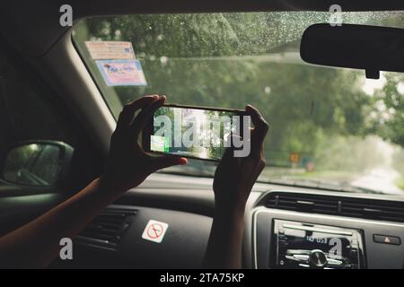 Les femmes utilisent l'application de navigation ou gps sur smartphone sur le fond intérieur de la voiture floue. Les femmes tiennent un téléphone portable avec une carte de localisation Banque D'Images