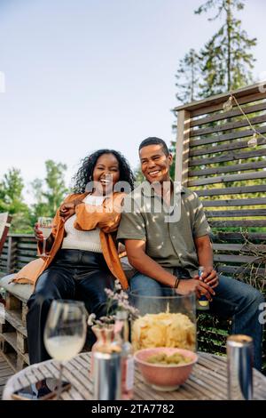 Femme joyeuse s'amusant avec un ami masculin à la fête Banque D'Images