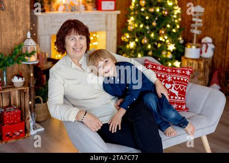 Grand-mère et enfant à la maison à noël, la lecture, l'écriture de la lettre, la cuisson, profiter des vacances de Noël Banque D'Images