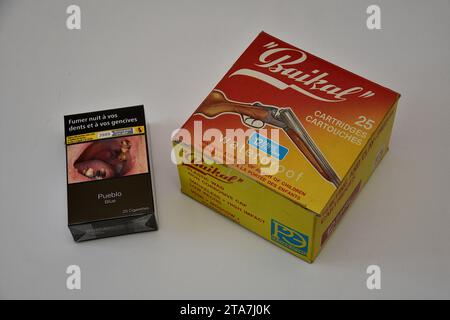 Sur cette photo illustrative, un paquet de cigarettes et une boîte de cartouches de chasse sont vus sur la surface de la table. Les magasins de tabac pourront vendre des munitions de fusil de chasse à partir du 1 janvier 2024. Pour obtenir la certification nécessaire. (Photo Gerard Bottino / SOPA Images/Sipa USA) Banque D'Images