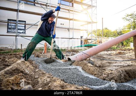 Homme étalant du béton frais pour une fondation de bâtiment Banque D'Images