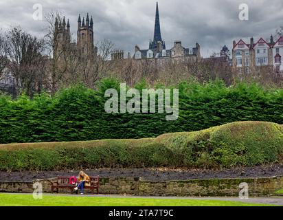 Édimbourg Écosse Princes Street Gardens fille lisant dans le parc sur un banc au début de l'hiver Banque D'Images