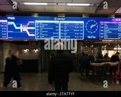 Un voyageur de sexe masculin regarde les horaires de l'Eurostar sur un panneau d'affichage à la gare internationale de St Pancras, Londres, Angleterre. Banque D'Images