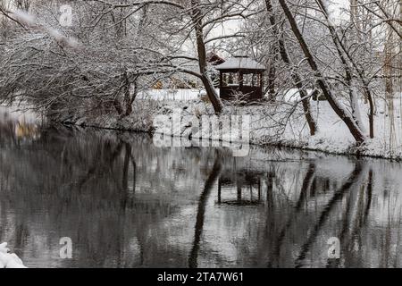 Un petit belvédère en bois dans les profondeurs d'une forêt d'hiver près d'un ruisseau de montagne froid et noyés marchent le long de lui, grimpant d'une vallée forestière. Banque D'Images