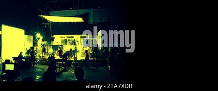 Silhouette des personnes travaillant dans le grand studio de production pour la prise de vue ou l'enregistrement de vidéo de film par appareil photo numérique et ensemble d'éclairage. Banque D'Images