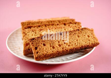 Gâteau indien maison Rusk | biscuits secs isolés sur fond rose, mise au point sélective Banque D'Images