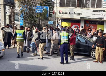 Les agents de police sont en alerte pour éviter un incident fâcheux pendant la grève appelée par les chauffeurs de pick-up, à Shahrah-e-Resham à Abbottabad le mercredi 29 novembre 2023. Banque D'Images