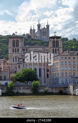 Lyon, France - juin 10 2018 : petit bateau passant par la Cathédrale Saint-Jean-Baptiste et la Basilique notre-Dame de Fourvière. Banque D'Images