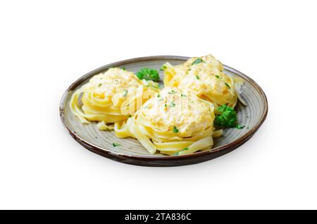 Pâtes nids avec sauce crémeuse sur une assiette, pâtes fraîchement cuites sur fond blanc Banque D'Images