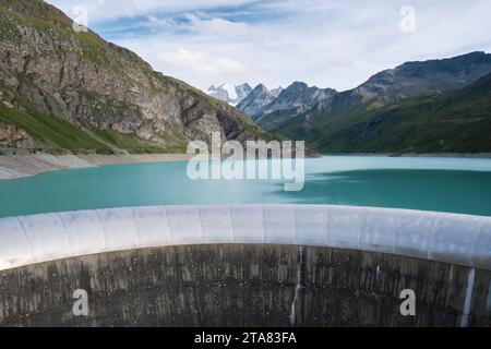Déversoir du barrage de Moiry et eau turquoise du lac de Moiry, à la tête de la vallée de Grimentz, en Suisse, avec des montagnes enneigées et Moiry Glaci Banque D'Images