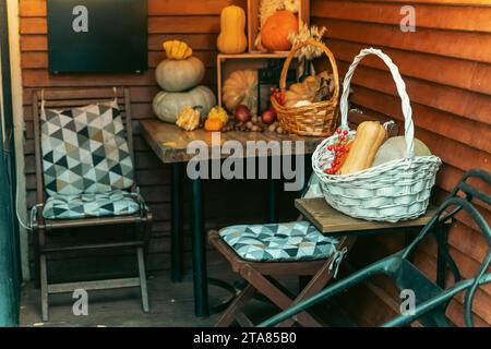 Cozy City Street Cafe Table DecorateUne table de café confortable sur une rue de la ville ornée de citrouilles d'automne mûres, créant une atmosphère chaleureuse et accueillante pour Banque D'Images