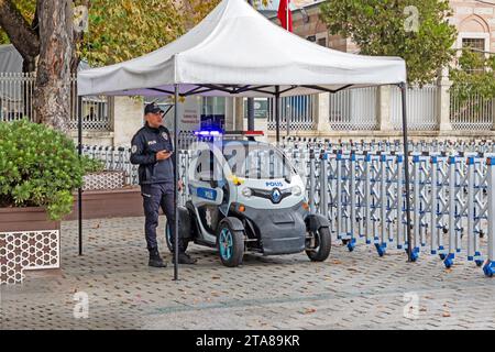 Istanbul, Turquie - 18 octobre 2023 : voiture électrique dans la rue à Istanbul montrant des soins pour la protection de l'environnement avec un policier sous la tente Banque D'Images