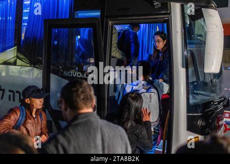 Ramle, Israël. 29 novembre 2023. Des travailleurs migrants thaïlandais, qui ont été libérés par le groupe militant Hamas après avoir été en captivité pendant plus de 50 jours, montent dans un bus après avoir quitté l’hôpital. Crédit : Ilia Yefimovich/dpa/Alamy Live News Banque D'Images