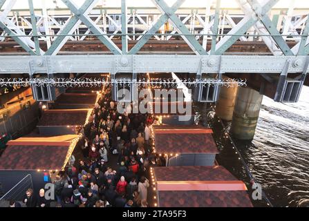 Les chalets alimentaires du marché hivernal Southbank Centre pour Noël 2023, sous Hungerford Bridge, à Londres, Royaume-Uni Banque D'Images