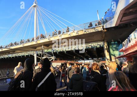 Les chalets du Southbank Winter Market 2023 sous Hungerford Bridge, par une journée ensoleillée, à Londres, Royaume-Uni Banque D'Images