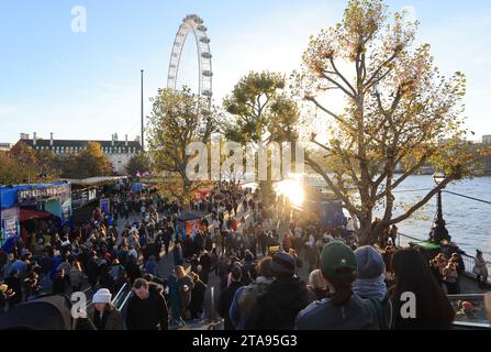 Foules sur la rive sud pour le Winter Market 2023, avec le London Eye Beyond, sous un soleil éclatant, Royaume-Uni Banque D'Images