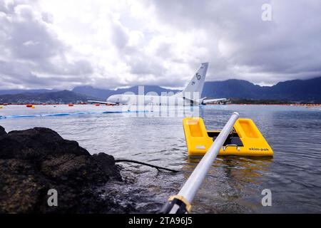 Kaneohe Bay, États-Unis. 26 novembre 2023. Un écumeur liquide de surface est déployé comme mesure préventive lors des opérations de ravitaillement sur un avion P-8a Poseidon de l'US Navy abattu qui a dépassé la piste dans l'eau à la base aérienne du corps des Marines Kaneohe Bay, le 26 novembre 2023 dans la baie de Kaneohe, Hawaii. Crédit : Sgt. Brandon Aultman/É.-U. Marine corps/Alamy Live News Banque D'Images