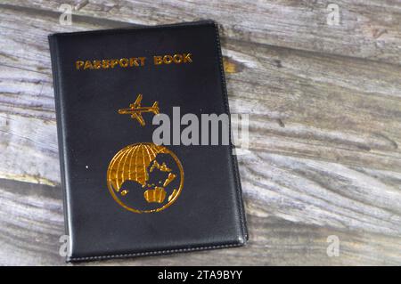 Livre de passeport noir avec un avion et la terre du globe sur sa couverture, concept de voyage et de tourisme, livre de passeport universel pour protéger le passeport Identifiant Banque D'Images