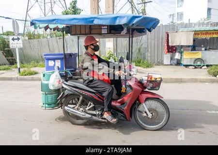 SAMUT PRAKAN, THAÏLANDE, SEP 30 2023, le vendeur de boissons conduit une moto avec un stand mobile Banque D'Images