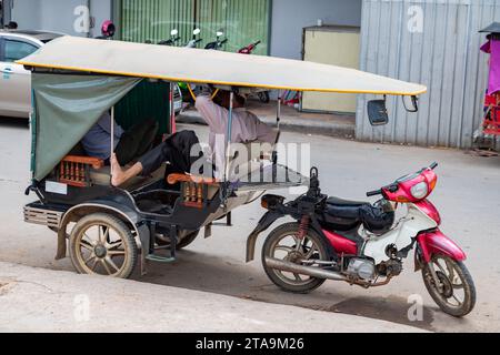 Les chauffeurs de taxi tricycle font une pause dans les rues de Phnom Penh, Cambodge Banque D'Images