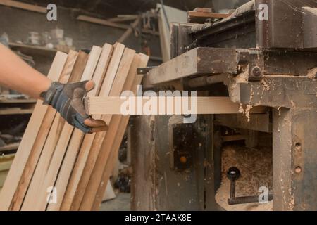 Main Homme travailleur machine-outil équipement atelier industriel entreprise traitement du bois planches en bois. Banque D'Images