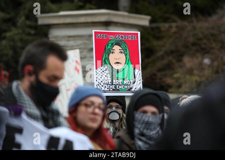 University Park, États-Unis. 29 novembre 2023. Une femme tient une pancarte en faveur de la Palestine lors d'un rassemblement pro-palestinien à State College, Pennsylvanie, le 29 novembre 2023. Les manifestants se sont rassemblés à Allen Street de Penn State, puis ont marché vers Old main pour présenter leurs revendications, qui incluent le désinvestissement des fabricants d'armes et une condamnation de la « guerre de génocide israélienne en cours contre la Palestine », à l'administration de l'université. (Photo de Paul Weaver/Sipa USA) crédit : SIPA USA/Alamy Live News Banque D'Images