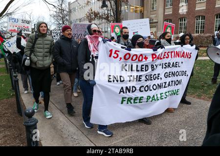 University Park, États-Unis. 29 novembre 2023. Des manifestants brandissent des pancartes et des drapeaux lors d'un rassemblement pro-palestinien à State College, Pennsylvanie, le 29 novembre 2023. Les manifestants se sont rassemblés à Allen Street de Penn State, puis ont marché vers Old main pour présenter leurs revendications, qui incluent le désinvestissement des fabricants d'armes et une condamnation de la « guerre de génocide israélienne en cours contre la Palestine », à l'administration de l'université. (Photo de Paul Weaver/Sipa USA) crédit : SIPA USA/Alamy Live News Banque D'Images