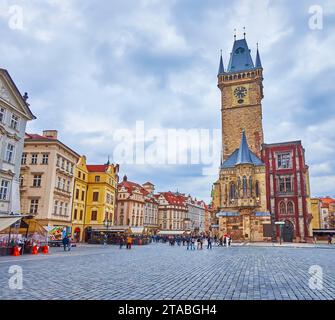 L'ancien hôtel de ville médiéval avec un haut tour d'horloge en pierre contre les maisons colorées et les dîners en plein air, Prague, Tchéquie Banque D'Images