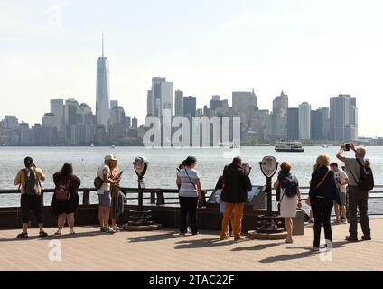 New York, États-Unis - 09 juin 2018 : les gens regardent le quartier financier dans le bas Manhattan depuis l'île de la liberté. Banque D'Images