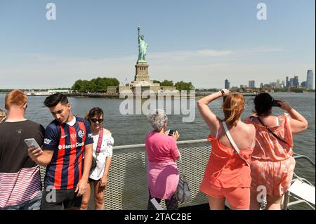 New York, USA - 09 juin 2018 : les passagers du ferry de Statue Cruises voient et font une photo de la Statue de la liberté. Banque D'Images