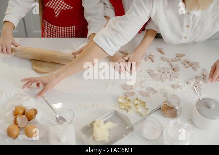 Vue de dessus, mère avec enfants faisant des biscuits de Noël dans la cuisine. Banque D'Images