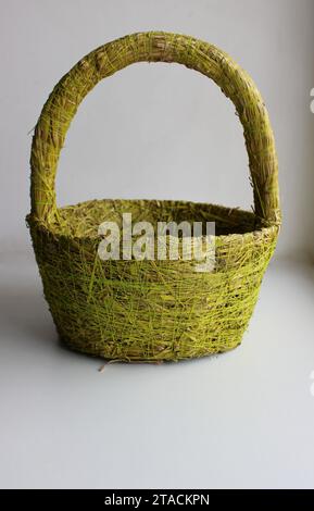 Panier tissé fabriqué à partir d'osier, de fibres de plantes et de fils isolé sur blanc Banque D'Images